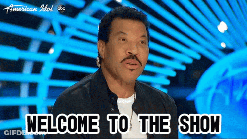 A Man With A Mustache Says Welcome To The Show On A Blue Background GIF
