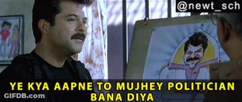 A Man With A Mustache Talks To Another Man In Front Of A Cartoon Of A Man With A Mustache GIF