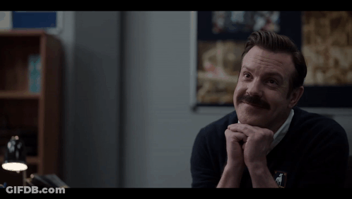 A Man With A Mustache Wearing A Black Sweater With A Horse On It GIF
