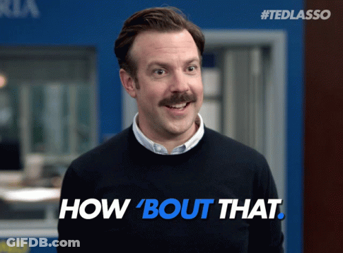 A Man With A Mustache Wearing A Black Sweater With The Words How Bout That On It GIF
