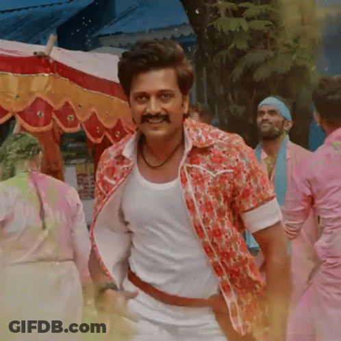 A Man With A Mustache Wearing A Floral Shirt And White Tank Top GIF