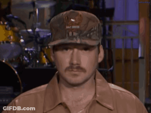 A Man With A Mustache Wearing A Hat And A Leather Jacket . GIF