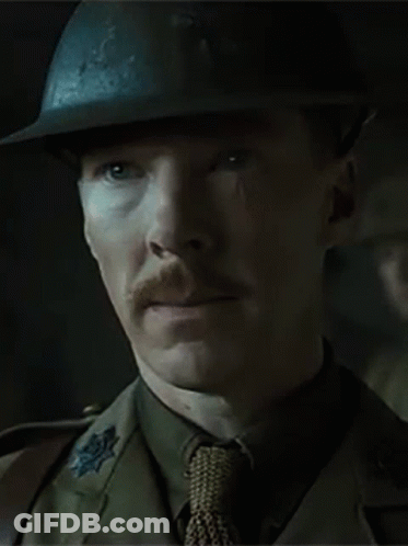 A Man With A Mustache Wearing A Helmet And Tie Is Looking At The Camera . GIF