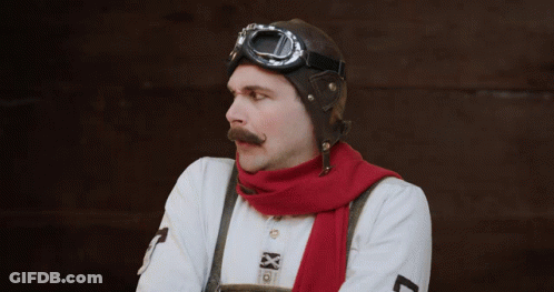 A Man With A Mustache Wearing A Red Scarf And A Helmet GIF