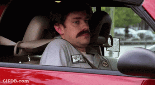 A Man With A Mustache Wearing A Shirt That Says Dunkin Donuts GIF