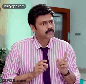 A Man With A Mustache Wearing A Striped Shirt And Tie Is Making A Funny Face . GIF