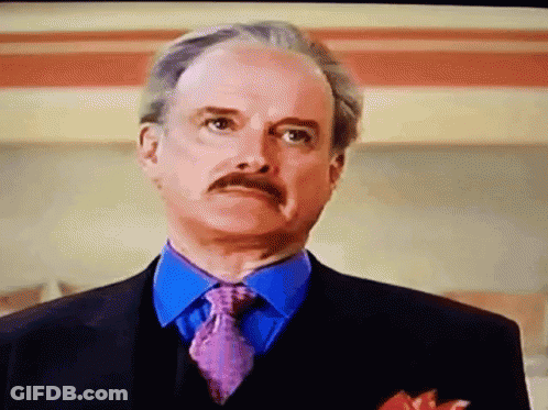 A Man With A Mustache Wearing A Suit And Tie GIF