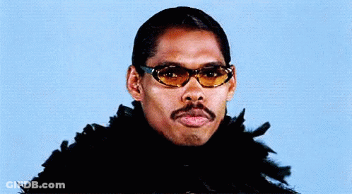 A Man With A Mustache Wearing Sunglasses And A Feather Boa . GIF