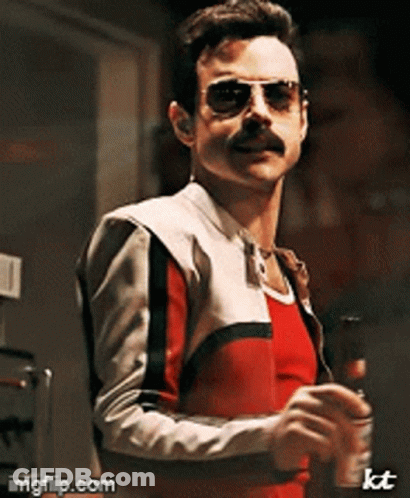 A Man With A Mustache Wearing Sunglasses And A Red And White Jacket GIF