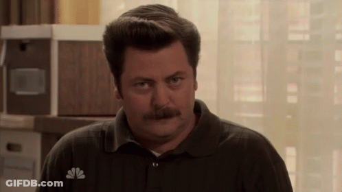 A Man With A Mustache Wears A Nbc Logo On His Shirt GIF