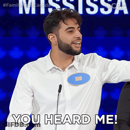 A Man With A Name Tag That Says Mo Stands In Front Of A Microphone And Says " You Heard Me " GIF