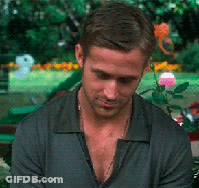 A Man With A Necklace Around His Neck Looks Down At Something GIF