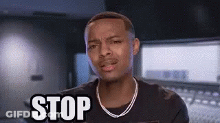 A Man With A Necklace Is Making A Stop Sign . GIF