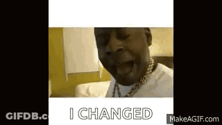 A Man With A Necklace On His Neck Is Sitting On A Bed And Saying `` I Changed '' . GIF