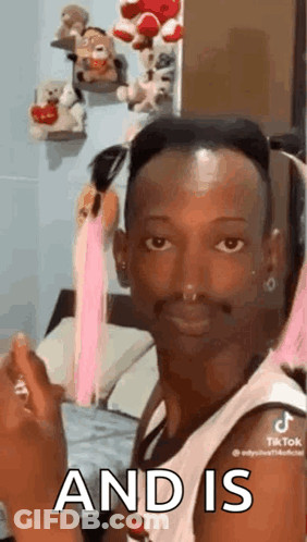 A Man With A Nose Ring Is Sitting On A Bed And Making A Face . GIF