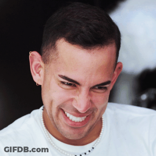 A Man With A Pearl Necklace Around His Neck Smiles For The Camera GIF