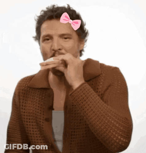 A Man With A Pink Bow On His Head Eating A Sandwich GIF