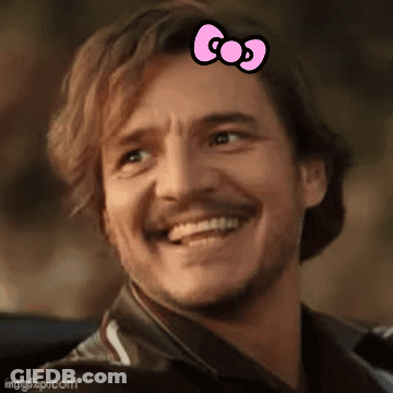 A Man With A Pink Bow On His Head Is Smiling And Looking At The Camera . GIF