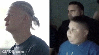 A Man With A Ponytail And A Boy With A Blue Shirt Are Sitting Next To Each Other GIF