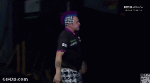 A Man With A Purple Mohawk Stands In Front Of A BBC America Logo GIF