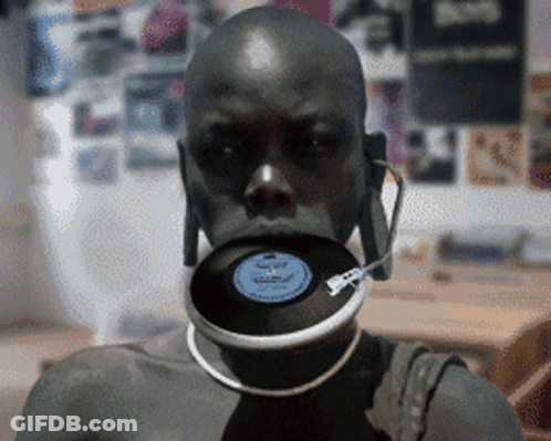 A Man With A Record In His Mouth And Headphones GIF