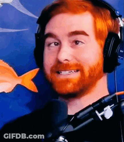 A Man With A Red Beard Is Wearing Headphones And Smiling . GIF