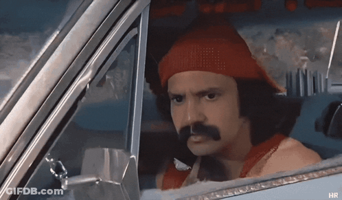 A Man With A Red Hat And Mustache Is In A Car GIF