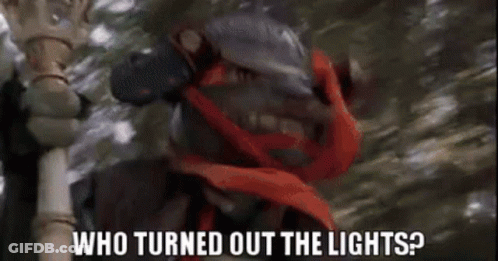 A Man With A Red Scarf Around His Neck Is Holding A Cane And Asking Who Turned Out The Lights . GIF