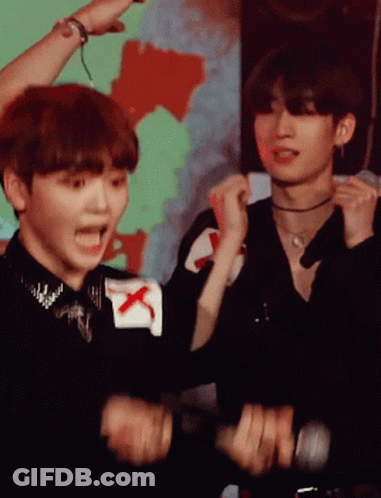 Man With Red X On Sleeve Standing Next To Another Man GIF
