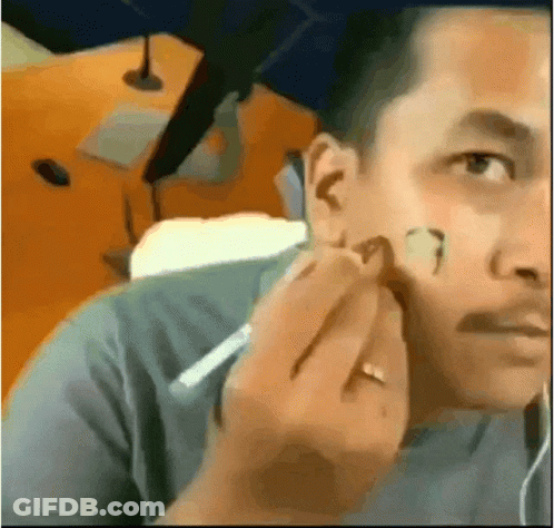 A Man With A Ring On His Finger Is Applying Makeup To His Face . GIF