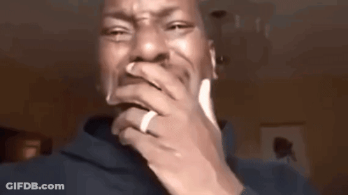 A Man With A Ring On His Finger Is Covering His Mouth With His Hands . GIF
