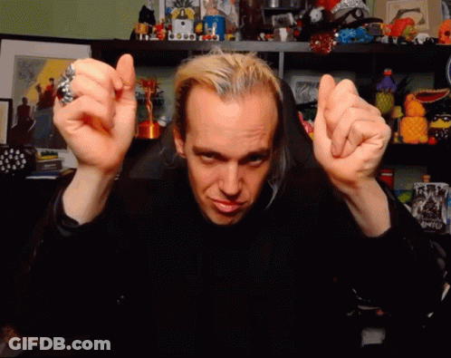 A Man With A Ring On His Finger Is Making A Face With His Hands GIF