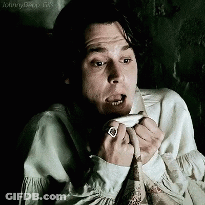 A Man With A Ring On His Finger Is Making A Funny Face While Sitting In A Chair . GIF