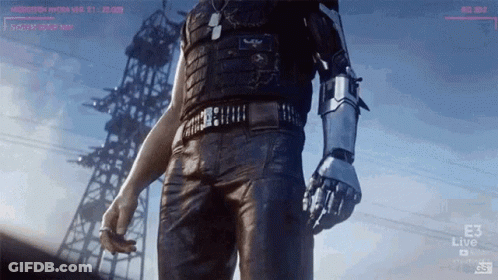 A Man With A Robot Arm Is Standing In Front Of A Tower GIF