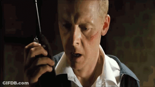 A Man With A Scar On His Face Is Holding A Walkie Talkie In His Hand GIF