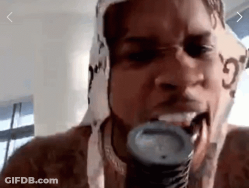 A Man With A Scarf Around His Head Is Eating A Can Of Soda . GIF