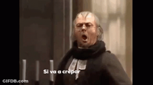 A Man With A Scarf Around His Neck Is Standing In Front Of Candles And Screaming . GIF