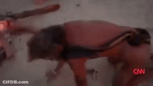 A Man With A Scarf Around His Neck Is Standing In The Desert . GIF
