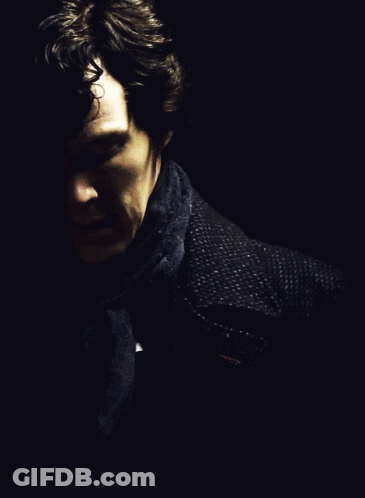 A Man With A Scarf Around His Neck Looks Down GIF