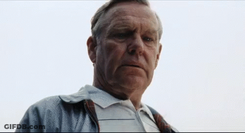 A Man With A Serious Look On His Face Is Wearing A Plaid Shirt GIF