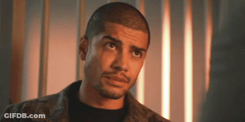 A Man With A Shaved Head And A Beard Is Looking Up At The Camera . GIF