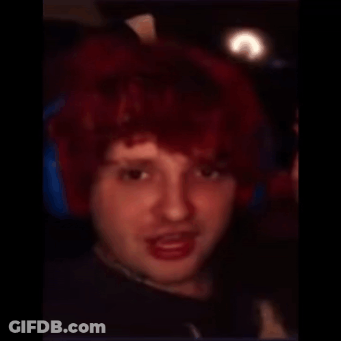 A Man With A Shaved Head And Red Hair Looks At The Camera GIF