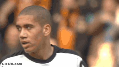 A Man With A Shaved Head Is Wearing A White Shirt GIF