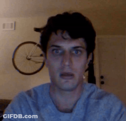 A Man With A Shocked Look On His Face Stands In Front Of A Bicycle GIF