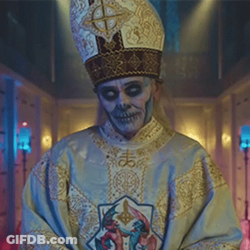A Man With A Skull Face Painted On His Face Is Wearing A Priest 'S Robe And Hat . GIF
