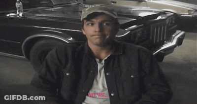 A Man With A Smiley Face On His Face Is Sitting In Front Of A Car GIF
