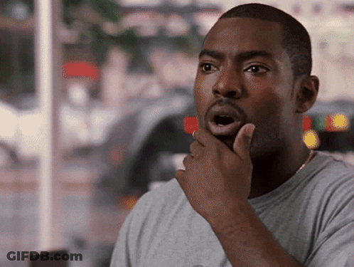 A Man With A Surprised Look On His Face Holds His Hand To His Chin GIF
