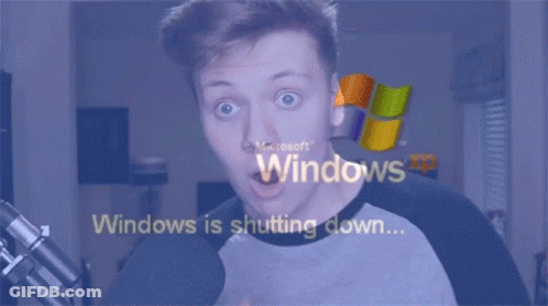 A Man With A Surprised Look On His Face Is Looking At A Screen That Says Windows Is Shutting Down GIF