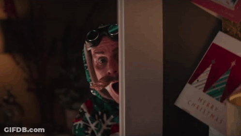 A Man With A Surprised Look On His Face Is Standing In Front Of A Christmas Card GIF