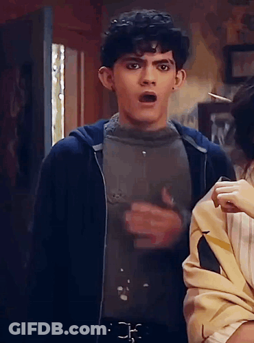 A Man With A Surprised Look On His Face Is Standing Next To A Woman In A Room . GIF